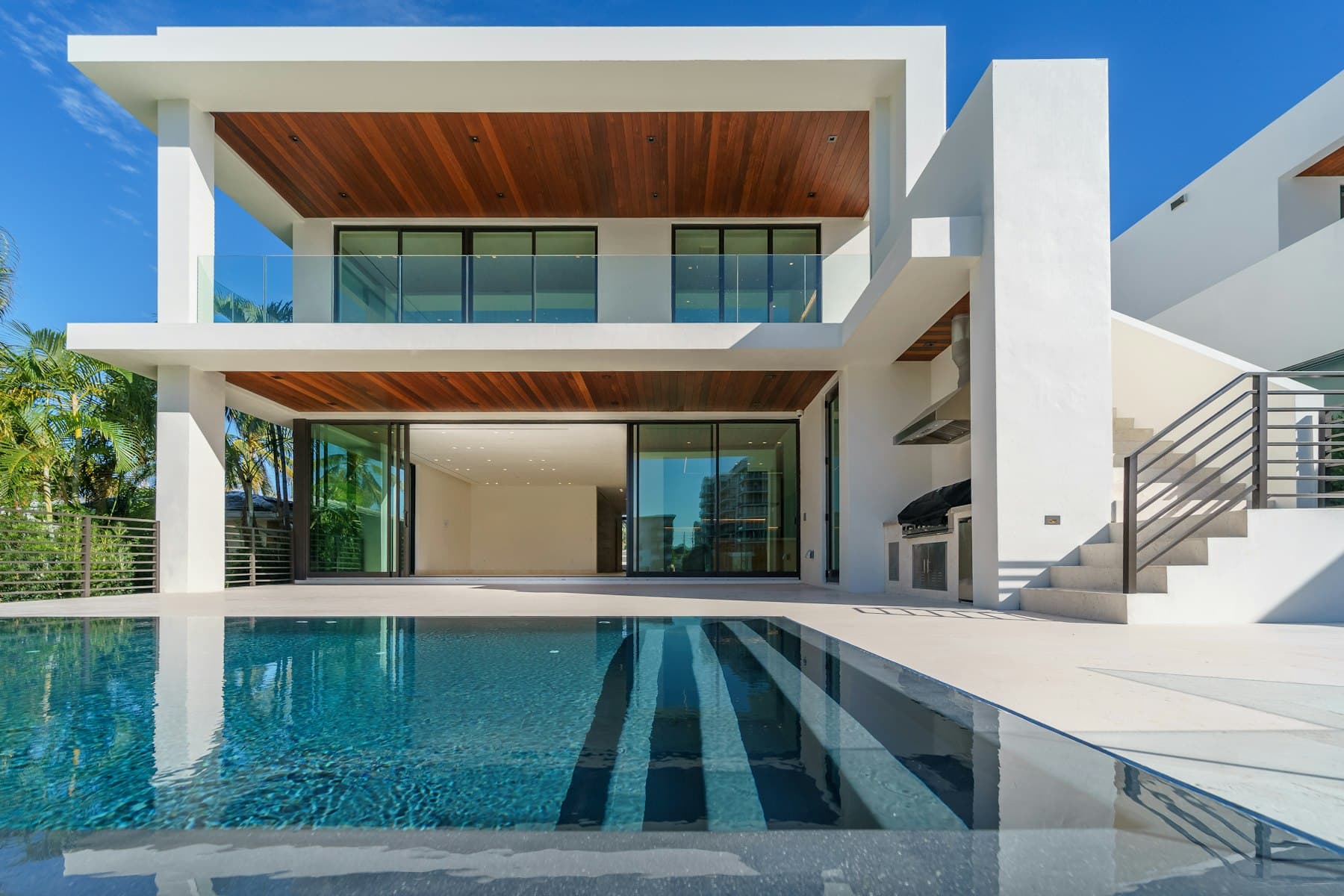 Double-height villa walkthrough opening to the pool