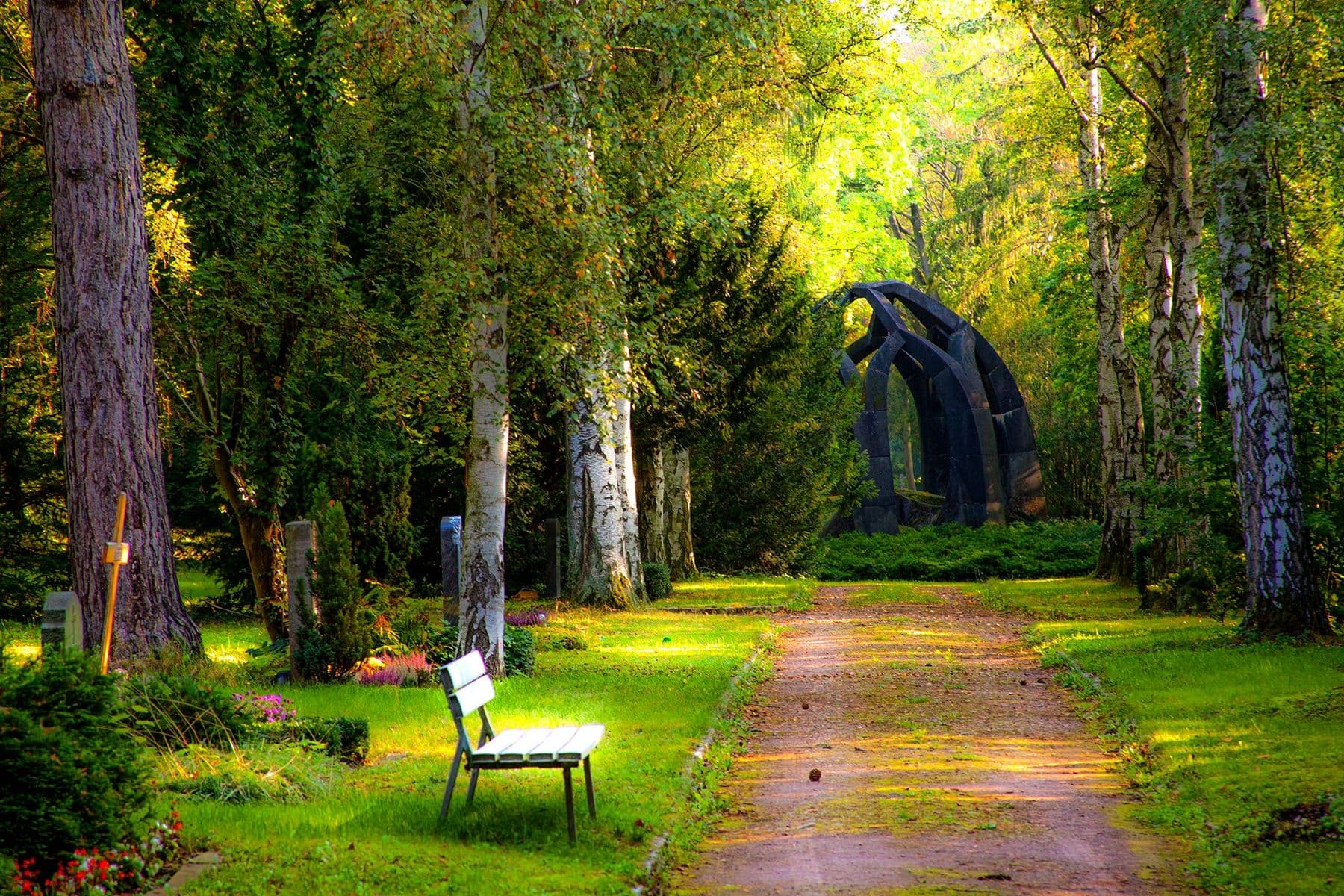Tree-lined garden path with lawn and seating